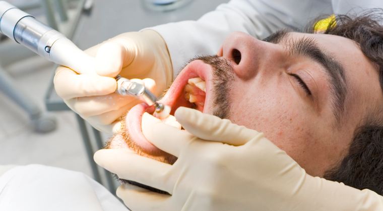 dentist cleaning a man's teeth