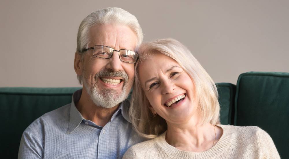Happy elderly couple smiling with good teeth